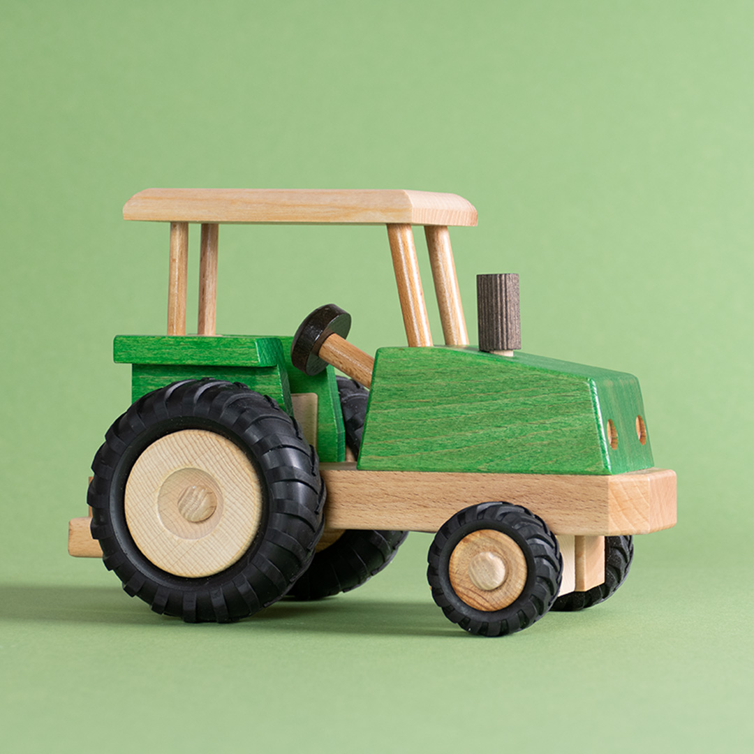 Seitenansicht eines grünen, lenkbaren Traktors von Beck.