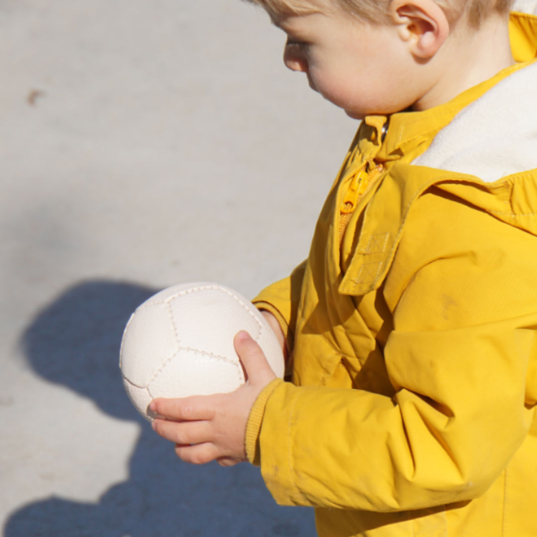 Der Ziegenlederball von Lautenbach wir von einem Kind in der Hand gehalten.