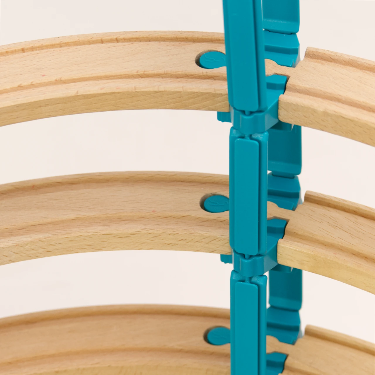 Das Adapter Set Helix 5 von Yamba ist aufgebaut in einem Detail Ausschnitt zu sehen. 3 Ebenen von Holzschienen sind jeweils durch ein Verbindungsstück LinkUp verbunden und seitlich von diesem Verbindungsstück gehen zwei Säuleelemente Lift nach oben und unten, damit kann man mehrere Etagen der Bahn übereinander bauen.