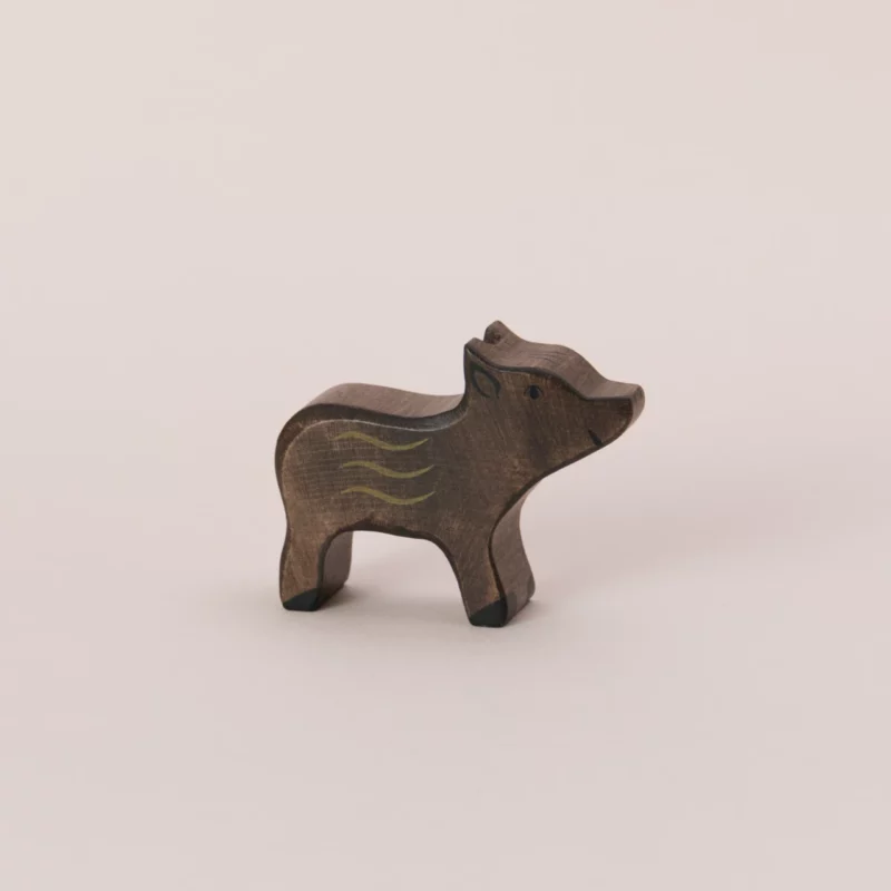 Handgefertigter Holztiger Frischling: naturbelassenes Holztier in Form eines jungen Wildschweins mit brauner Bemalung und typischen hellen Streifen, die die charakteristische Fellzeichnung eines Frischlings darstellen. Die Holzfigur ist 7 cm lang, 1,8 cm breit und 5,5 cm hoch, gefertigt aus massivem Ahorn- und Buchenholz, mit sanft abgerundeten Kanten und bemalt mit unbedenklichen Farben auf Wasserbasis. Ideal als robustes und kindgerechtes Spielzeug für Kinder ab 3 Jahren