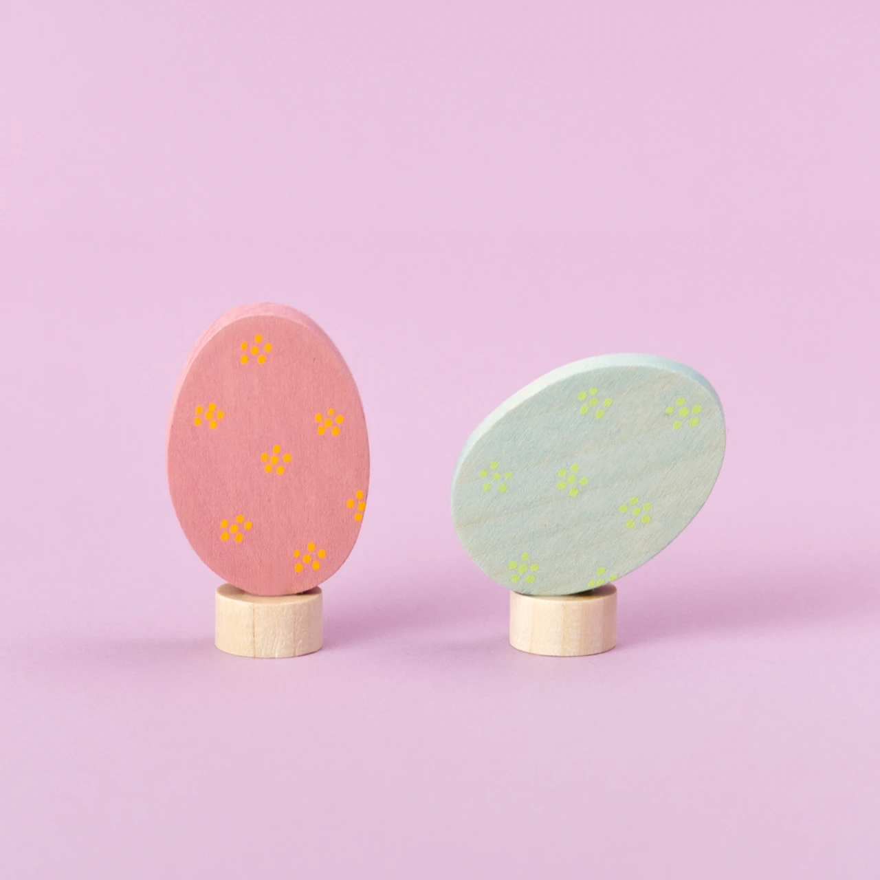 GRIMM'S Steckfiguren-Duo für den Festtagsring: Ein stehender und ein liegender Stecker in Osterei-Form, aus Holz in Rosa und Blau, verziert mit feinem Streublümchen-Muster. Perfekt für Frühling und Ostern.