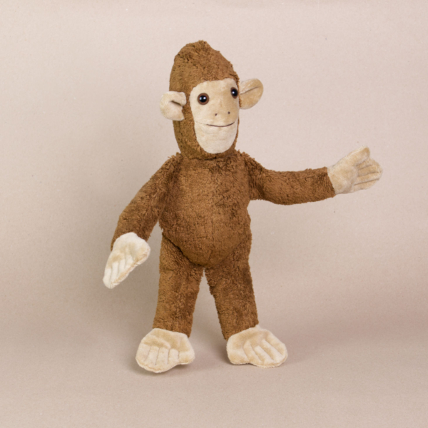 Vorderansicht des Kuscheltieres Affe namens Toto von Kallisto. Es hat braunes Plüschfell und braune Knopfaugen. Sein Körper steht aufrecht da.