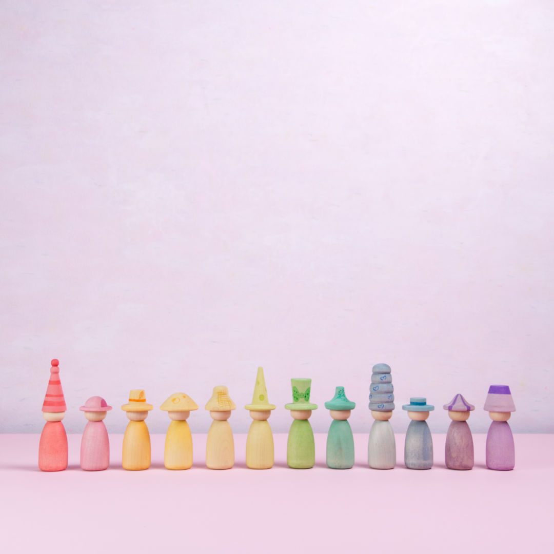 Insgesamt 12 in einer Reihe angeordnete Figuren mit abnehmbarem Hut und unterschiedlichen Farben von Grapat, tragen jeweils einen zu ihrer Figur passenden Hut