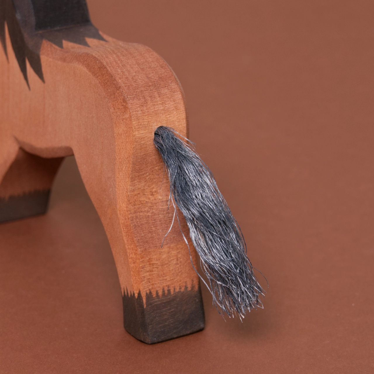 Detailaufnahme des Schweifs aus Naturhaar eines Kaltblutpferdes mit braunem Fell und dunkelbraunen Hufen und Mähne von Ostheimer.