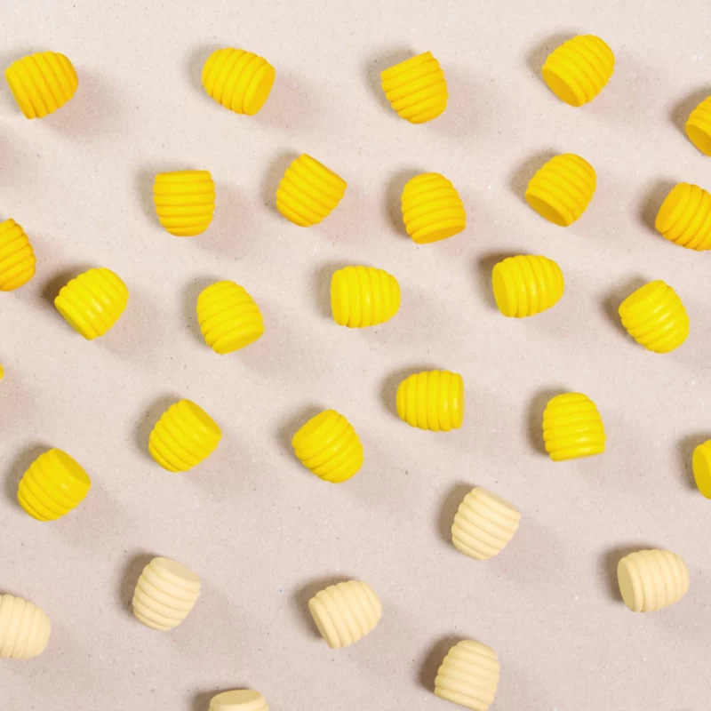 Komposition aus den Figuren aus dem Set Mandala honeycomb von Grapat. Alle Holzfiguren sind in drei unterschiedlichen Gelbtönen gehalten.