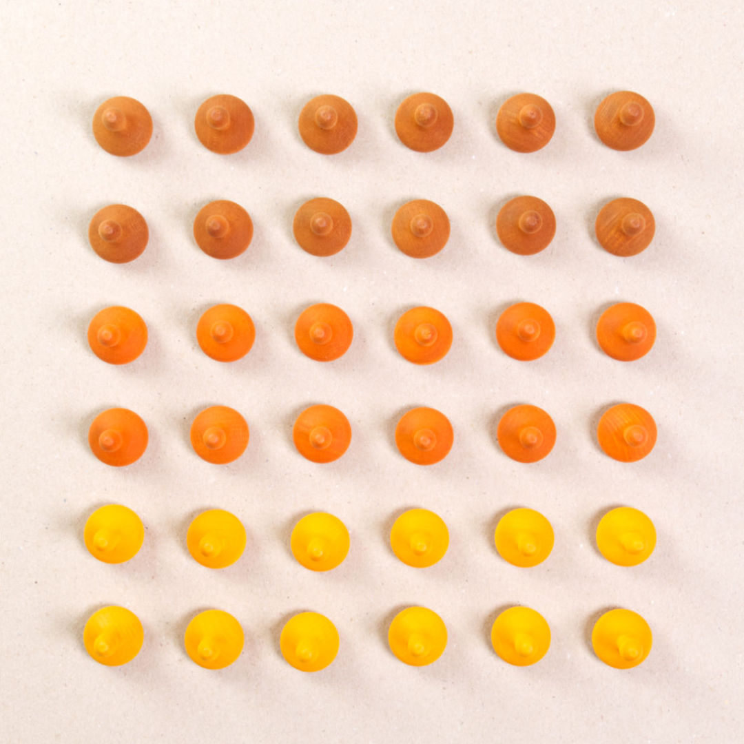 36 Kürbis Holzfiguren von Grapat in drei unterschiedlichen Farben. Hellbraun, orange und gelb. Gemeinsam als Quadratischer Blick aufgebaut. Ansicht von Oben.