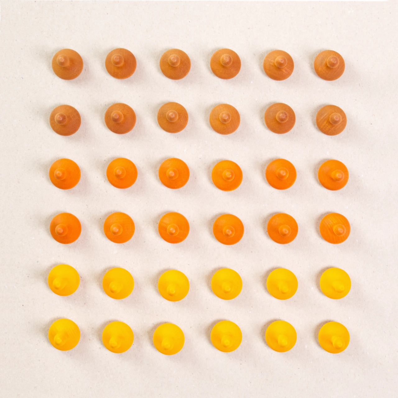 36 Kürbis Holzfiguren von Grapat in drei unterschiedlichen Farben. Hellbraun, orange und gelb. Gemeinsam als Quadratischer Blick aufgebaut. Ansicht von Oben.