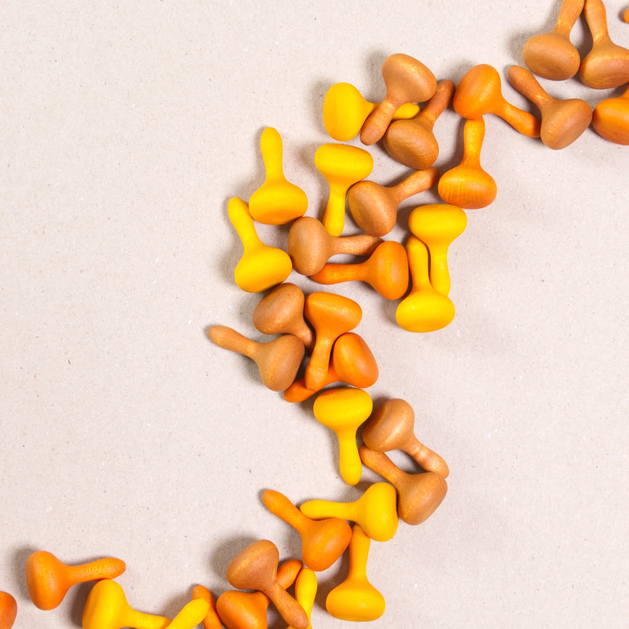 Komposition aus den Figuren aus dem Set Mandala pumpkin von Grapat. Alle Holzfiguren sind orange, braun und gelb.