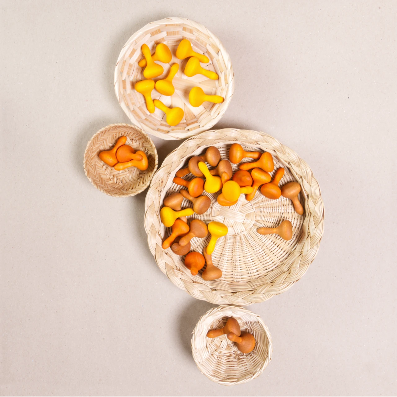 Komposition aus den Figuren aus dem Set Mandala pumpkin von Grapat. Alle Holzfiguren sind orange, braun und gelb. Alle sind in vier Körbchen aufgeteilt.