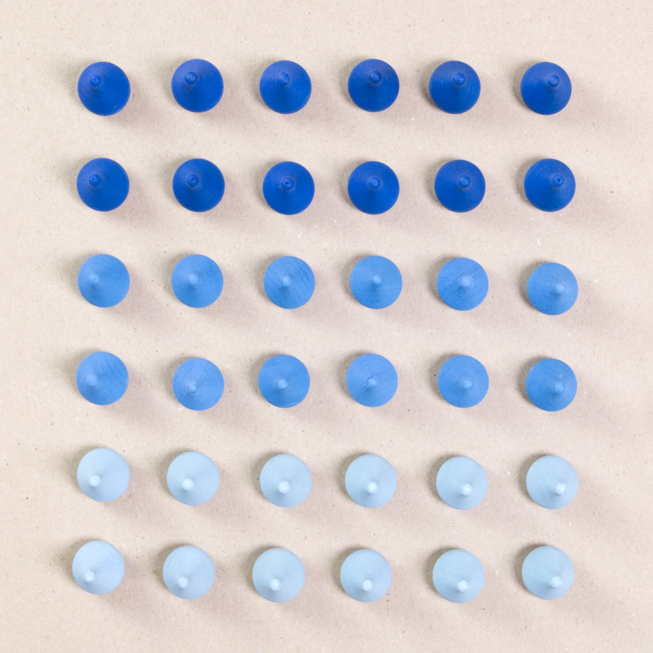 36 Regentropfen Holzfiguren von Grapat in drei unterschiedlichen Farben. Hellblau, blau und dunkelblau. Gemeinsam als Quadratischer Block aufgebaut. Ansicht von Oben.