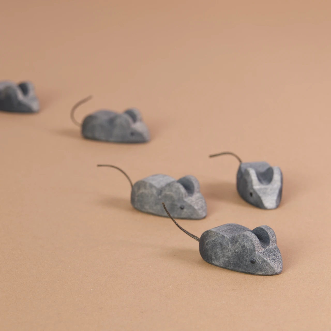 Komposition aus 5 Mäusen von Ostheimer. Alle haben einen Schwanz aus dünner schwarzer Schnur und einheitlich grauem Fell.