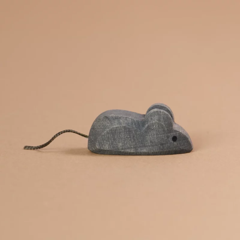 Eine graue Maus, von Ostheimer gefertigt, schaut mit ihrem schwarzen Schwanz aus einer dünnen Schnur nach rechts.