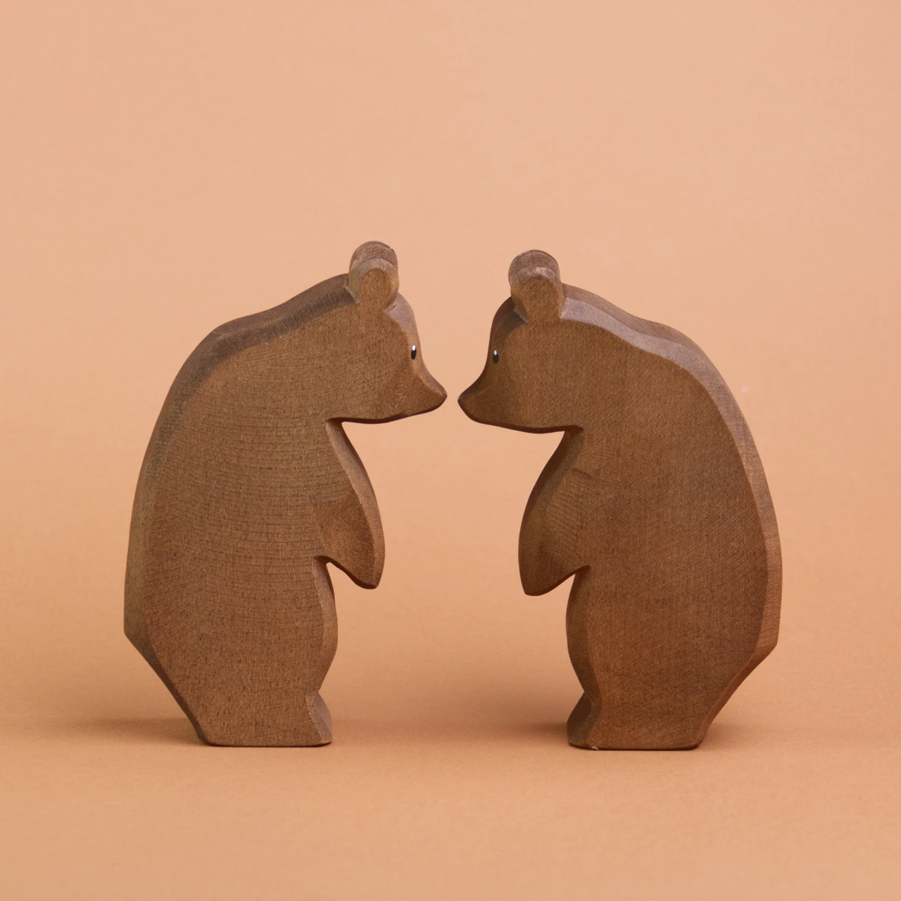 Zwei Bären aus Holz stehen sich gegenüber und schauen sich an. Sie berühren sich fast mit den Schnauzenspitzen und sind von der Mark Ostheimer.