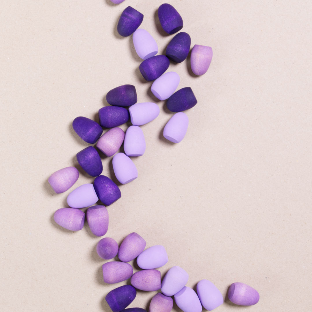 Komposition aus den Figuren aus dem Set Mandala purple eggs von Grapat. Alle Holzfiguren sind lila.