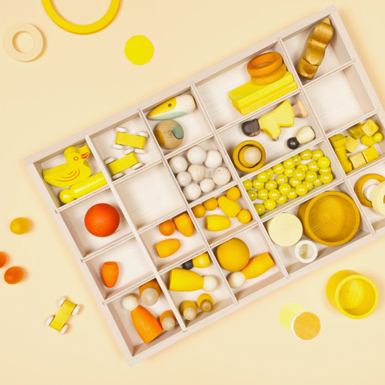 Mit gelben Spielzeug gefüllte großen Aufbewahrungsbox aus Holz mit je zwanzig Fächern.