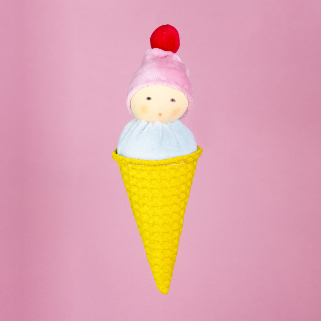 Vorderansicht des Plüschgreiflings "Eiswaffel" von Nanchen. Es trägt eine rosa Mütze mit rotem Bommel, ein hellblaues Oberteil und einen gelben Körper als Eiswaffel verkörpert.