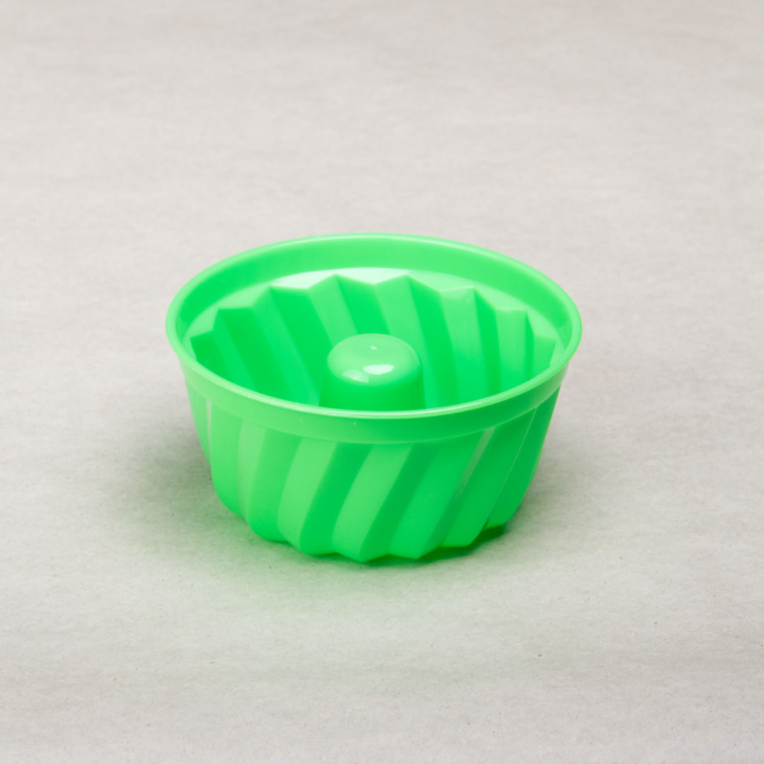 Grünes Gugelhupf Sandförmchen aus hochwertigem Kunststoff von Spielstabil mit der Öffnung nach oben hin offen.