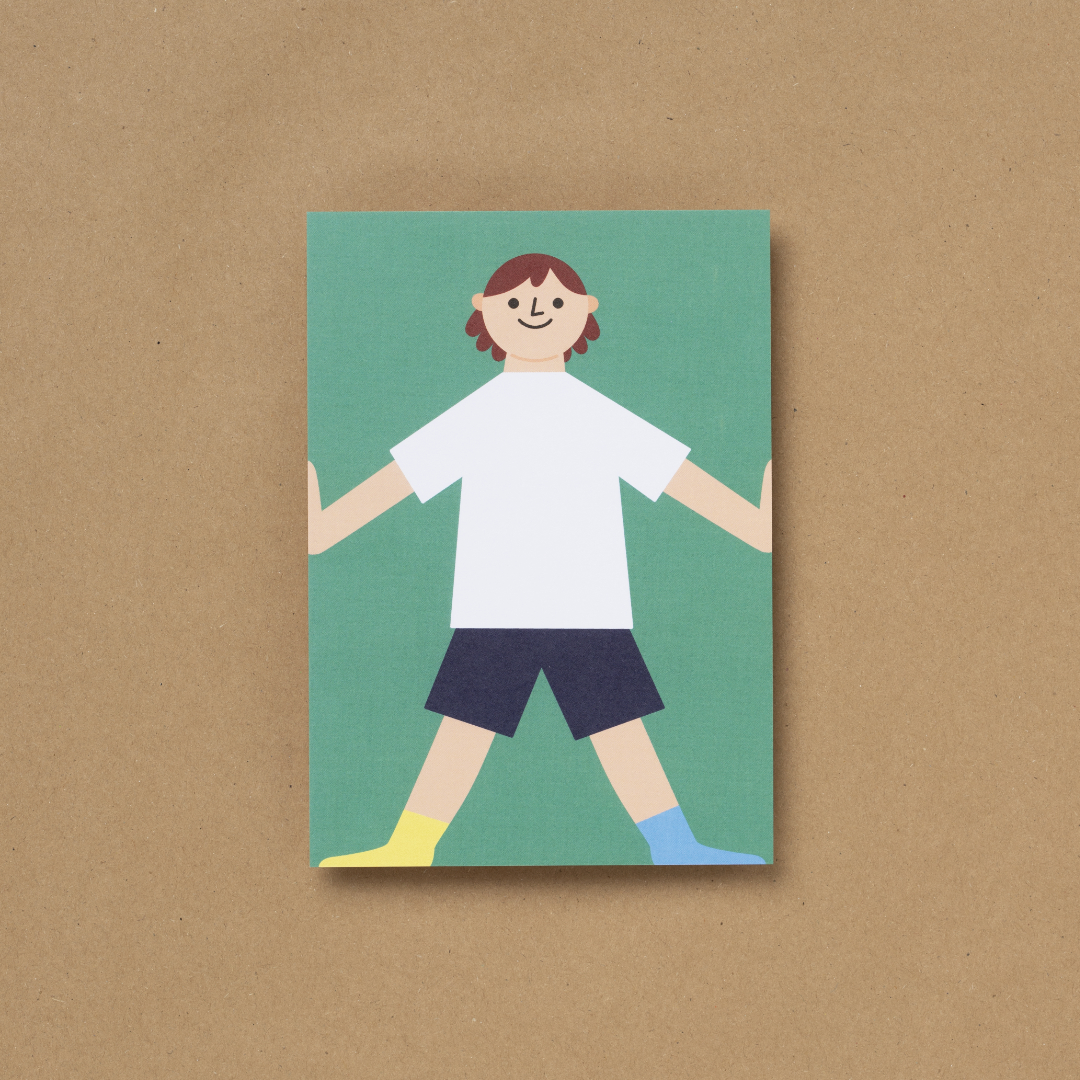 Die von Susann Stefanizen gestaltete Postkarte, mit dem Titel "Happy Kids XI" ist in der Draufsicht zu sehen. Es ist ein Junge mit einem weißen T-Shirt, einer dunkelblauen, langen Hose an und unterschiedlich farbigen Socken, zu sehen. Er hat lange dunkelbraune Haare und lächelt, seine beiden Arme hält er gestreckt an die Außenseiten der Karte. Der Hintergrund ist grün eingefärbt.