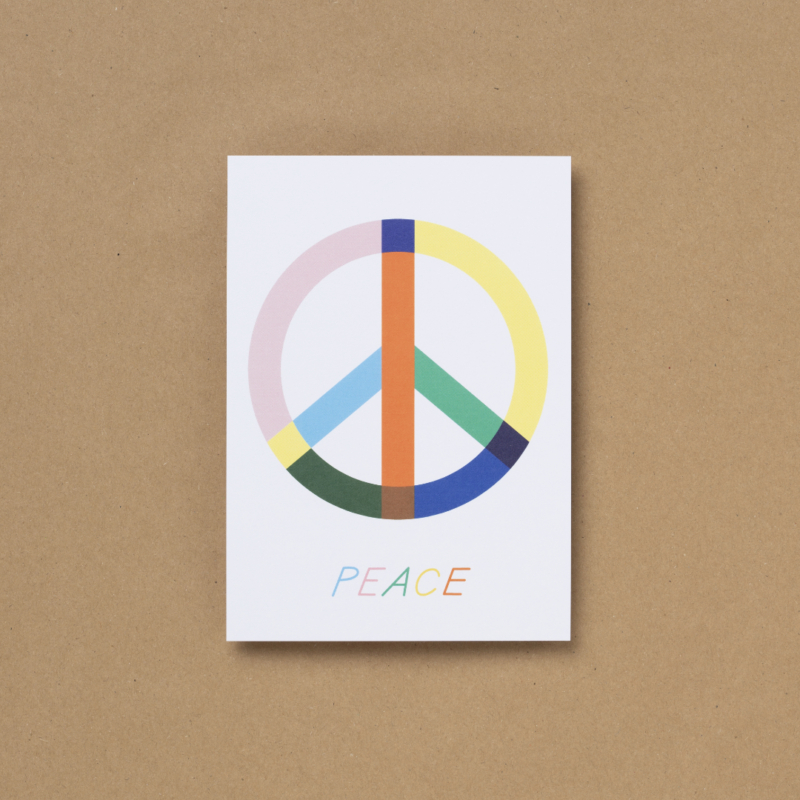 Die von Susann Stefanizen gestaltete Postkarte, mit dem Titel "Peace" ist in der Draufsicht zu sehen. In der Mitte ist ein großes Peace-Zeichen zu sehen, welches in den Farben rosa, dunkelblau, gelb, orange, hellblau, marineblau, grün und dunkelgrün eingefärbt. Darunter ist der Schriftzug "Peace" ebenso in bunten Farben abgebildet.
