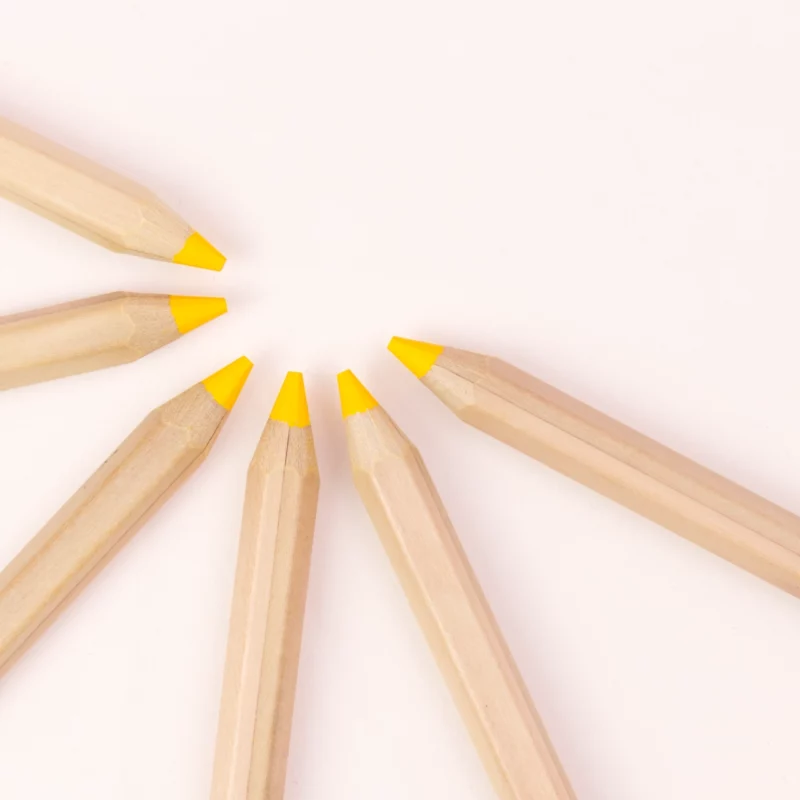 Stift von Stockmar in Goldgelb, 6-eckig. Sechs Stifte sind zu einem Halbkreis mit ihren Spitzen angeordnet.